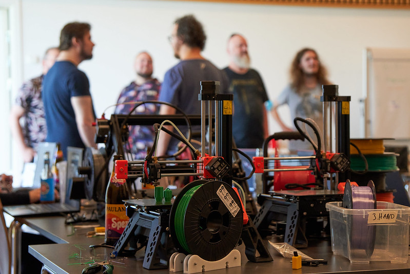 Im Vordergrund 3D Drucker im Hintergrund Menschen